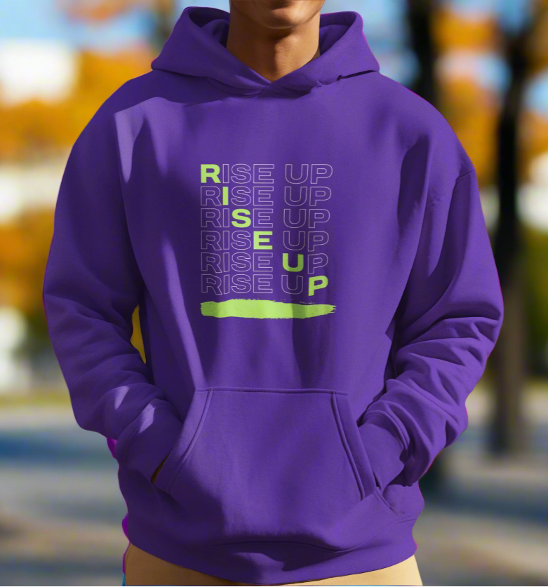 Person wearing a purple hoodie with 'RISE UP' text in a mountainous landscape